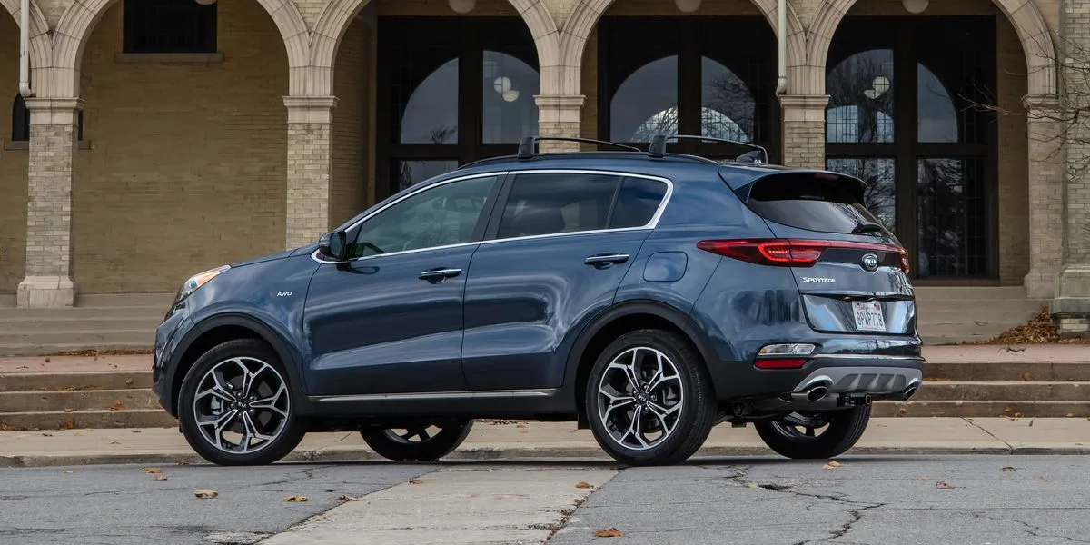 2020 kia sportage on the beach o Синий кроссовер возле здания с арками.