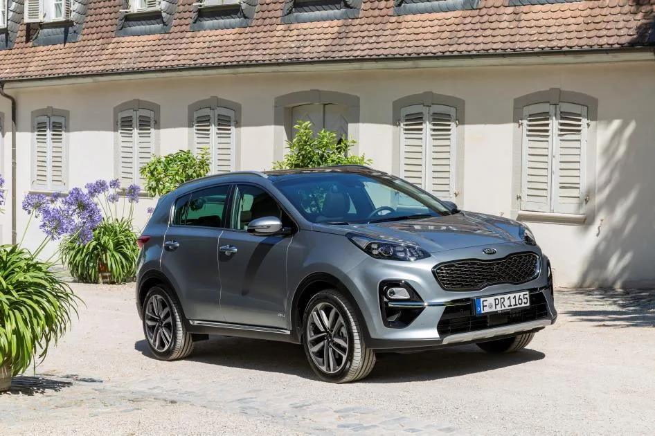kia sportage aussen vorne Серый кроссовер перед зданием с окнами
