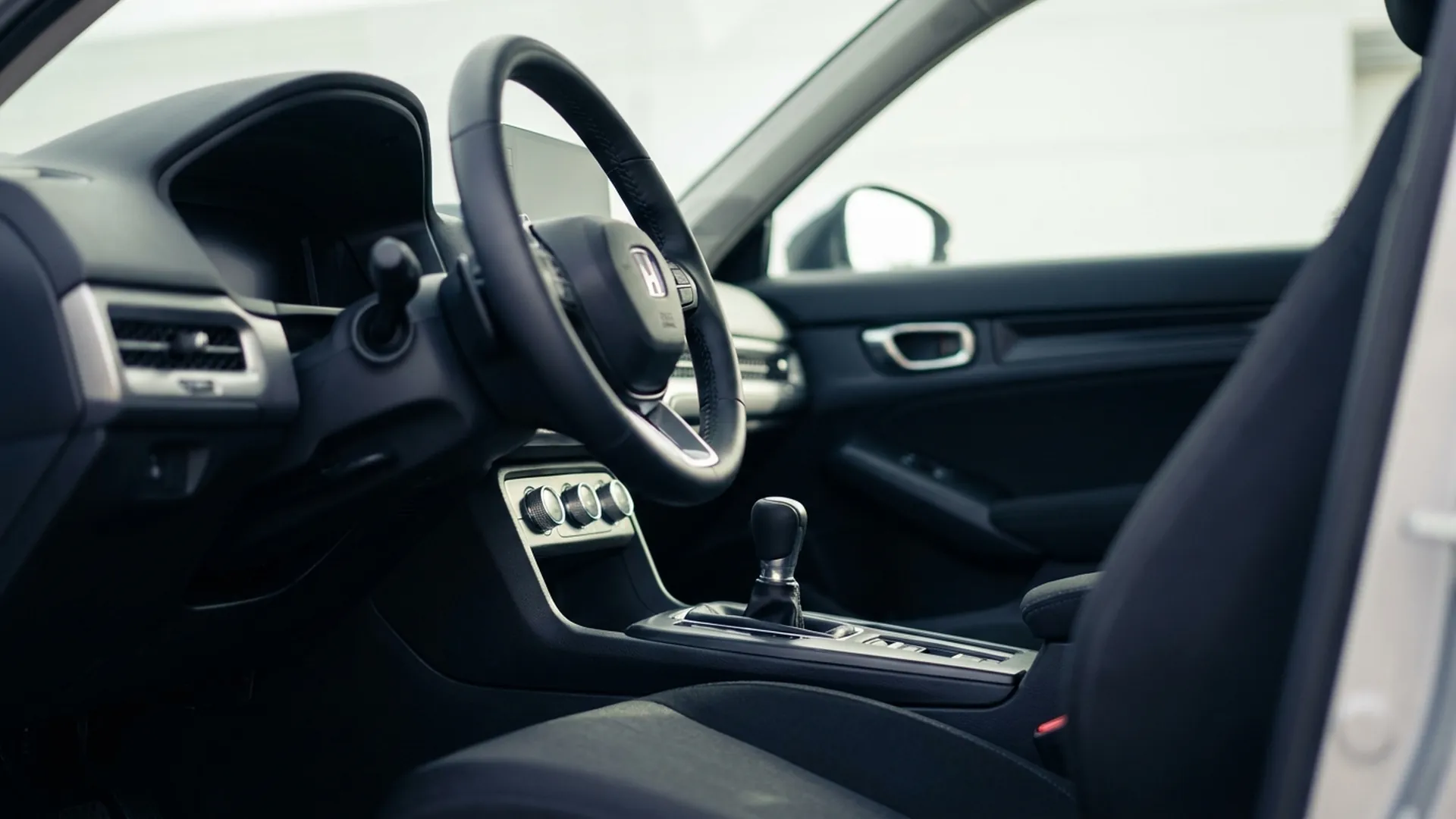 Салон компактного автомобиля: руль, кнопки климата и рычаг коробки передач